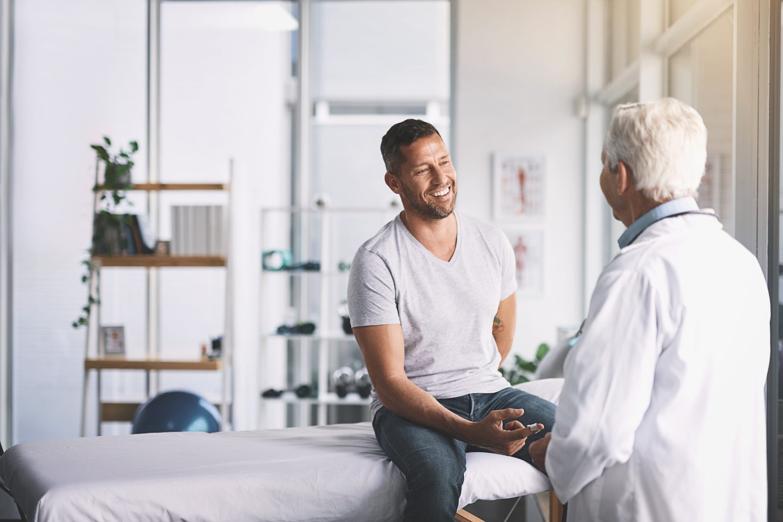 A patient smiling and chatting with their doctor during a consultation