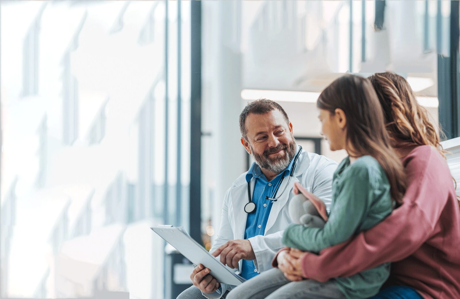 A doctor reviewing care details with a parent and child